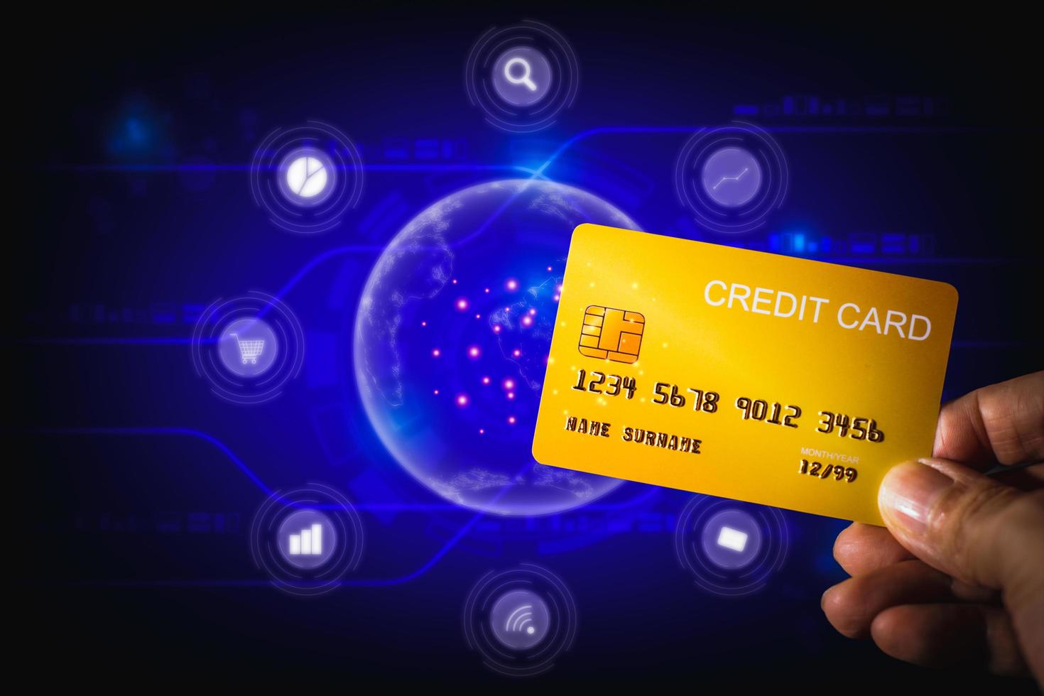 online winkelconcept. hand met gele creditcard op blauwe technische achtergrond. digitale betaling om thuis te winkelen. foto