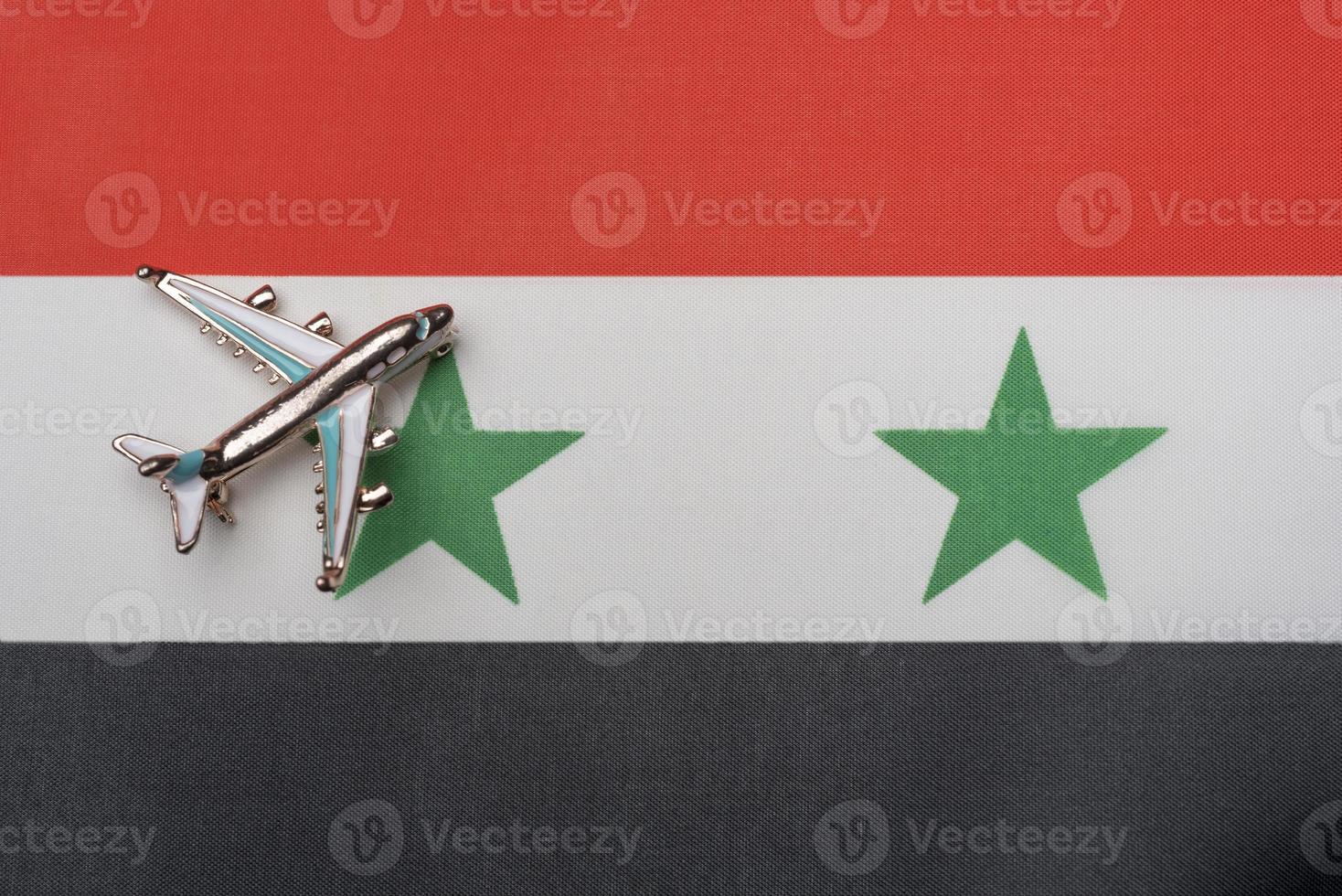 het vliegtuig boven de vlag van syrië, het concept van reizen. foto