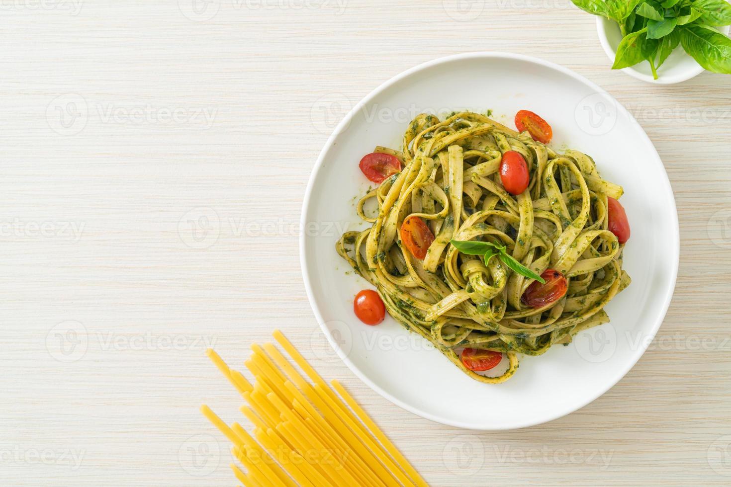 fettuccine spaghetti pasta met pestosaus en tomaten foto