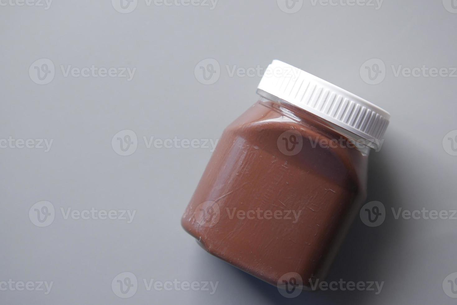 chocolade hazelnootroom in een container op zwarte achtergrond foto