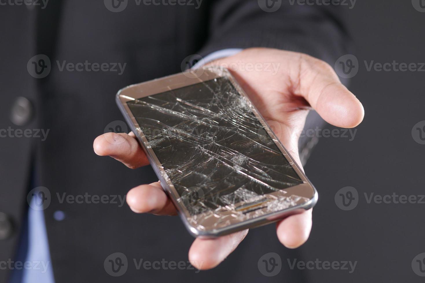 close-up van de hand van de man met gebroken slimme telefoon. foto