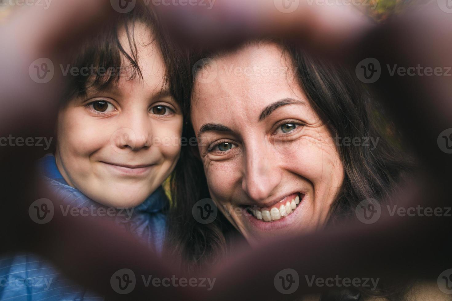 jongen met moeder gevouwen vingers in de vorm van een hart. foto