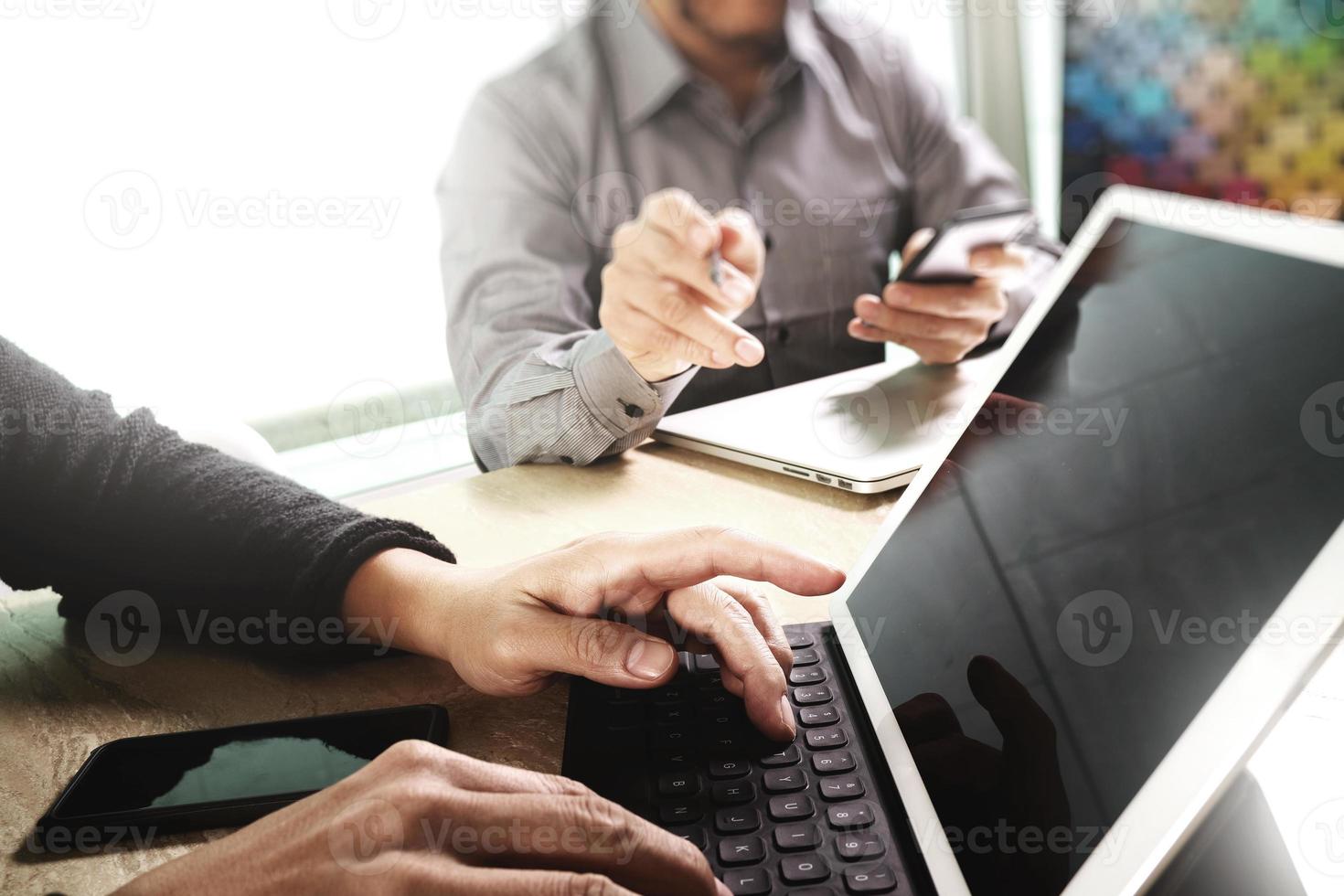 twee collega webdesigner bespreken gegevens en digitale tablet docking toetsenbord en computer laptop met smartphone en ontwerp diagram op marmeren bureau, zonlicht effect foto