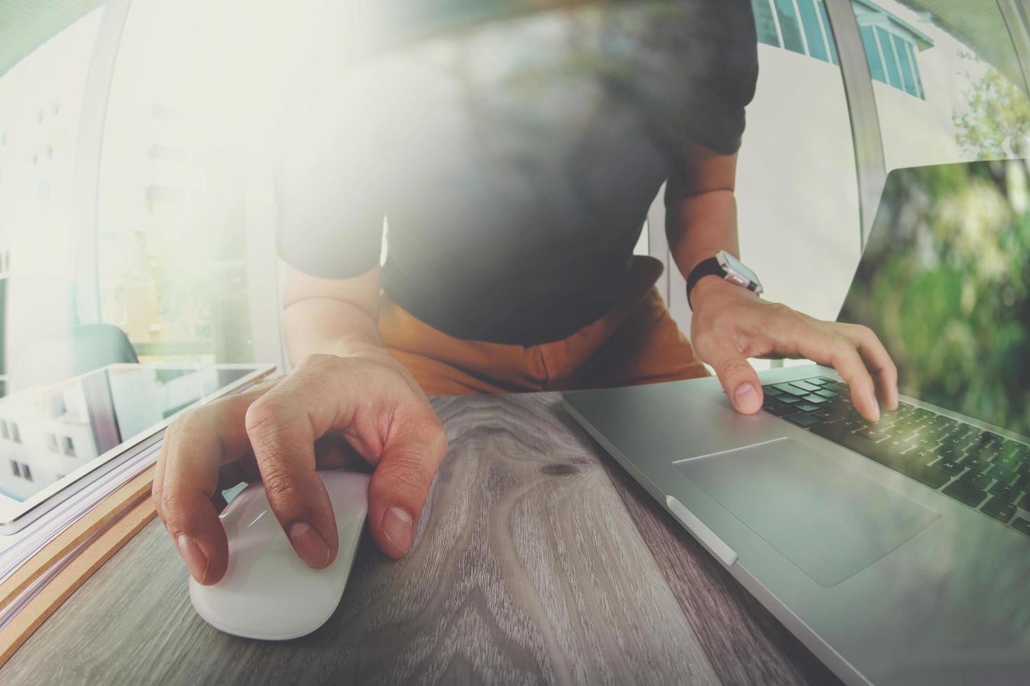 ontwerperhand die met laptopcomputer op houten bureau werkt als responsief webontwerpconcept foto