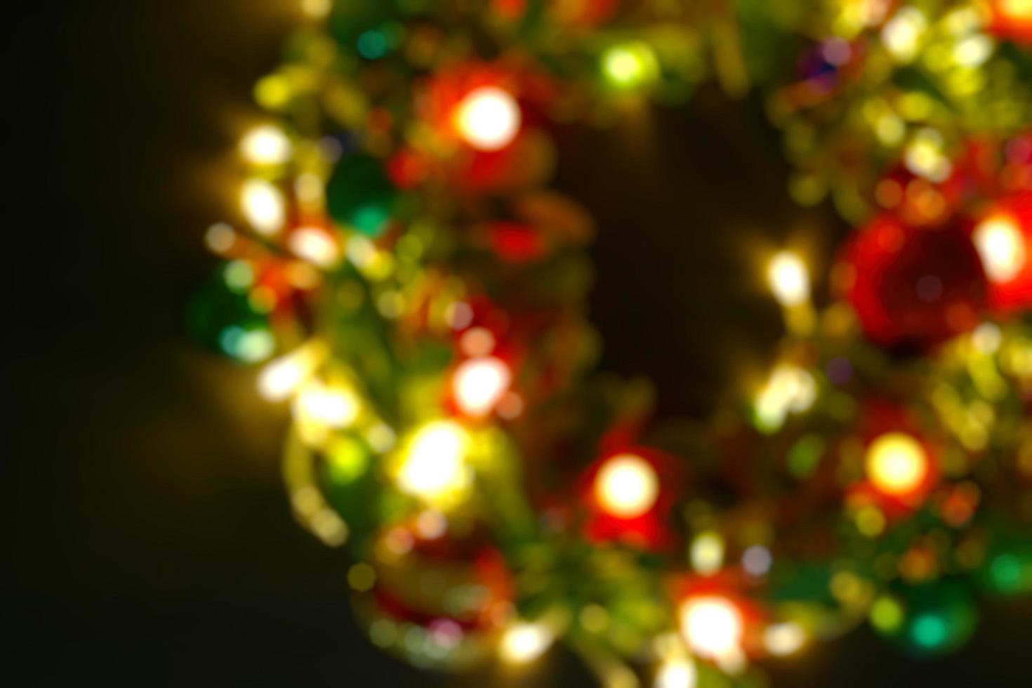 groet seizoen concept.blur kerstkrans met decoratief licht op donkere houten achtergrond foto