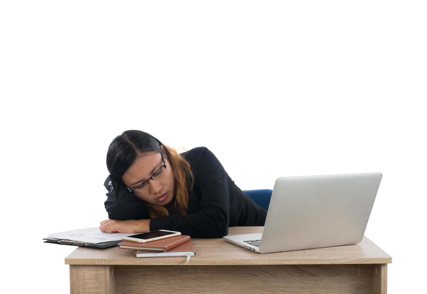 jonge zakenvrouw moe van haar werk in slaap vallen op haar bureau geïsoleerd op een witte achtergrond. foto