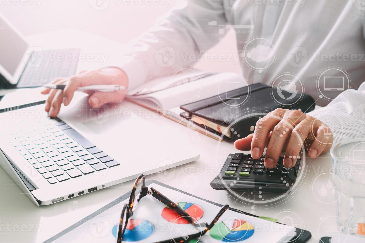 zakenman hand werken met financiën over kosten en berekenen en laptop met mobiele telefoon op met bureau in modern kantoor foto