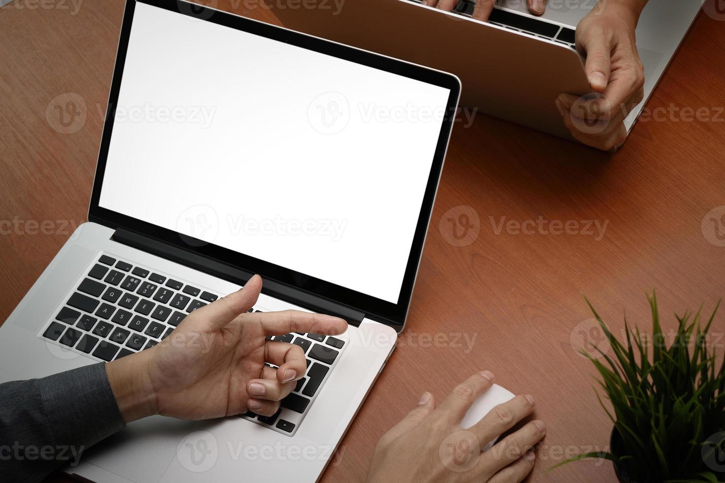 bovenaanzicht van zakenman hand werken met nieuwe moderne computer laptop met leeg scherm en blanco boek als concept foto