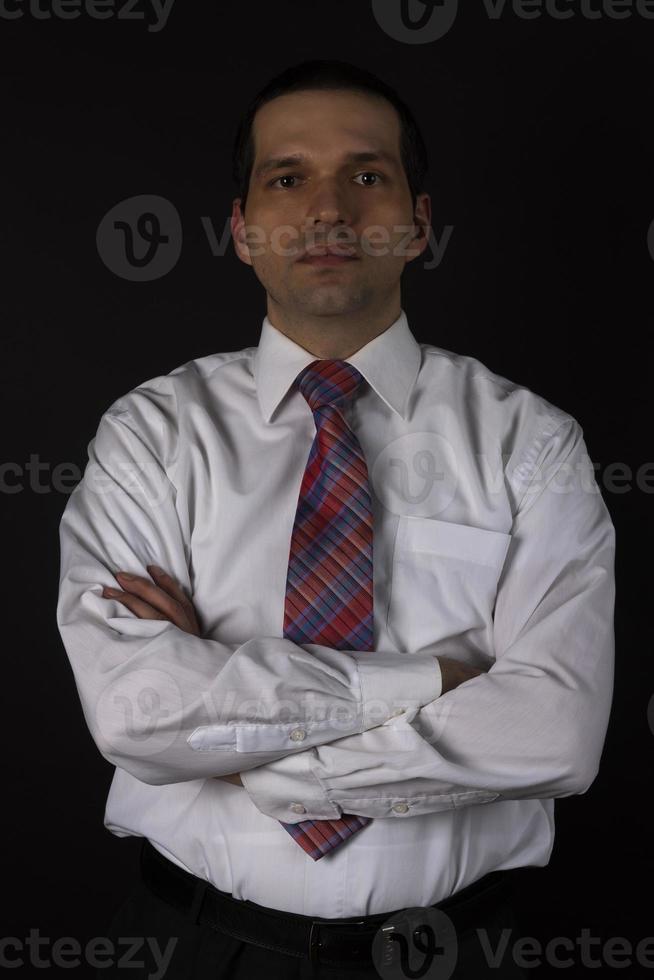 een man in een wit overhemd op een zwarte achtergrond. foto