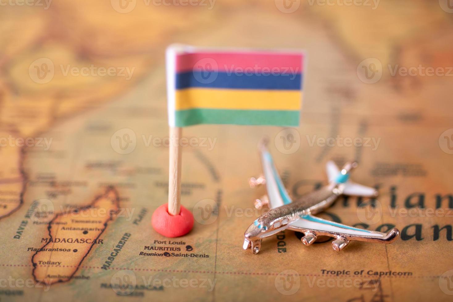 de vlag van mauritius en het vliegtuig op de wereldkaart. foto