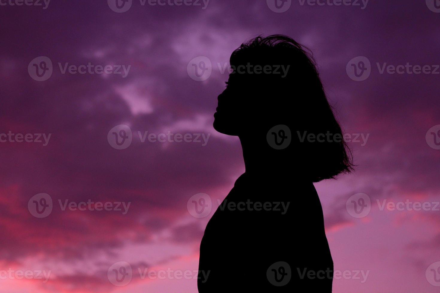 silhouet medium shot van vrouw of vrouw staande met de hemel zonsondergang achtergrond op de zonsondergang tijd. foto