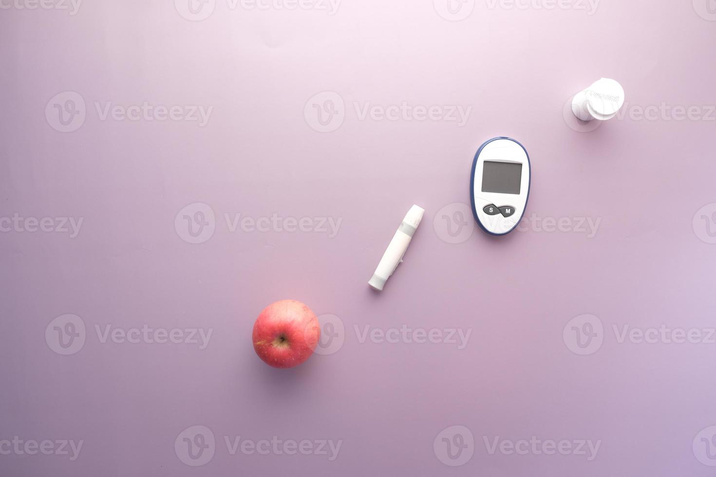 diabetische meetinstrumenten, appel op paarse achtergrond foto