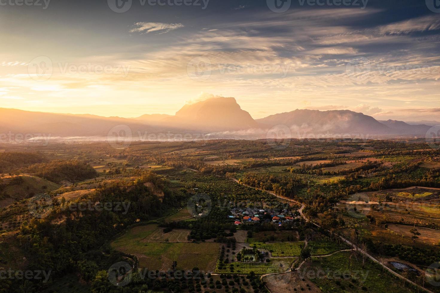 zonsopgang schijnt op de berg doi luang chiang dao met mist in landbouwgrond op het platteland van chiang dao foto