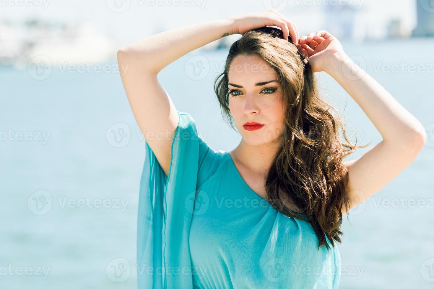 vrouw met blauwe ogen, gekleed in blauwe jurk op het strand. foto