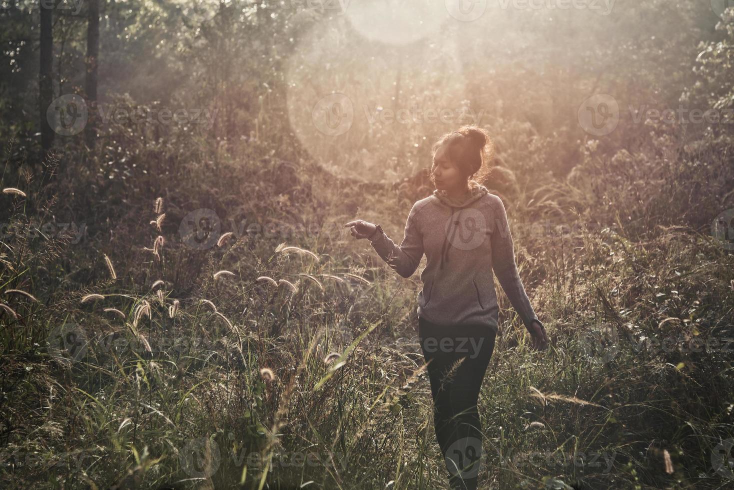 een jonge vrouw wandelen trekking door een groen pad in forest mountain zomer zonsopgang thailand. foto