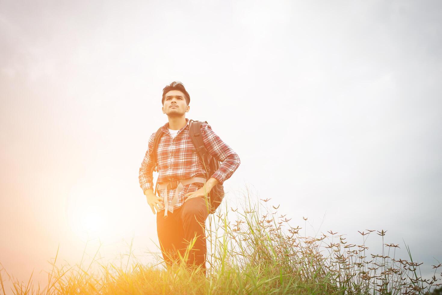 portret van jonge hipster man buiten verhogen handen met rugzak op zijn schouder, avontuurlijk toerisme. foto