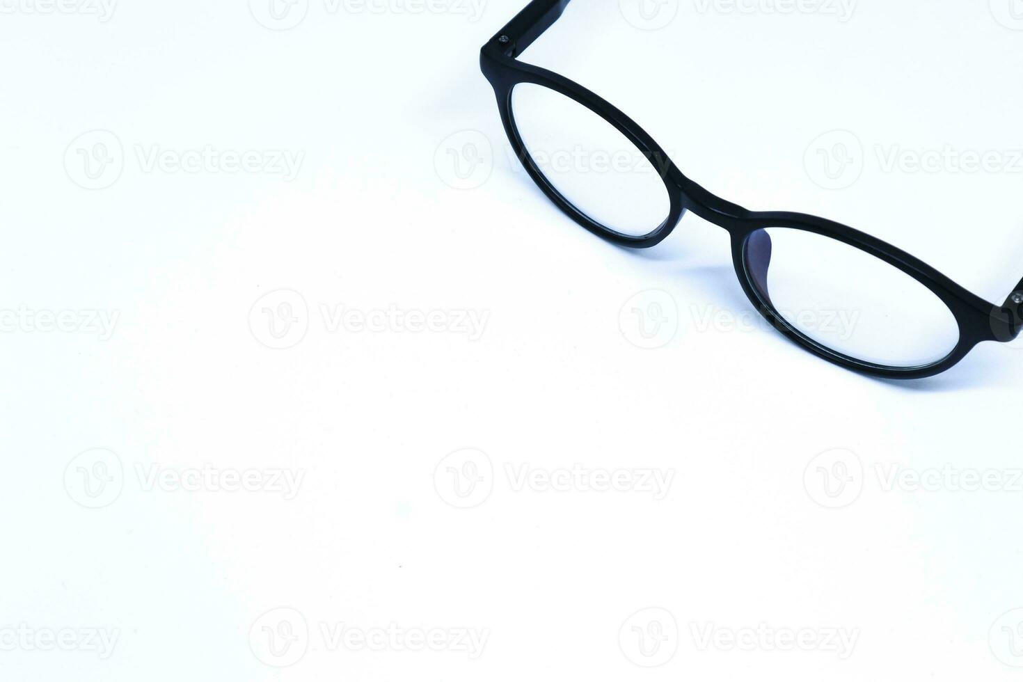 zwarte bril in de hoek van minimalistische witte achtergrond met schuin bovenschot, landschapsmodus foto