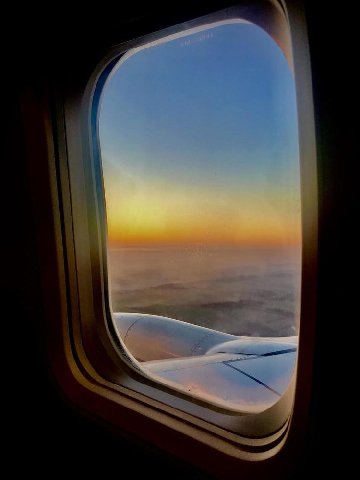 prachtig uitzicht vanuit vliegtuigraam, grote vleugel van vliegtuig toont openslaand raam foto