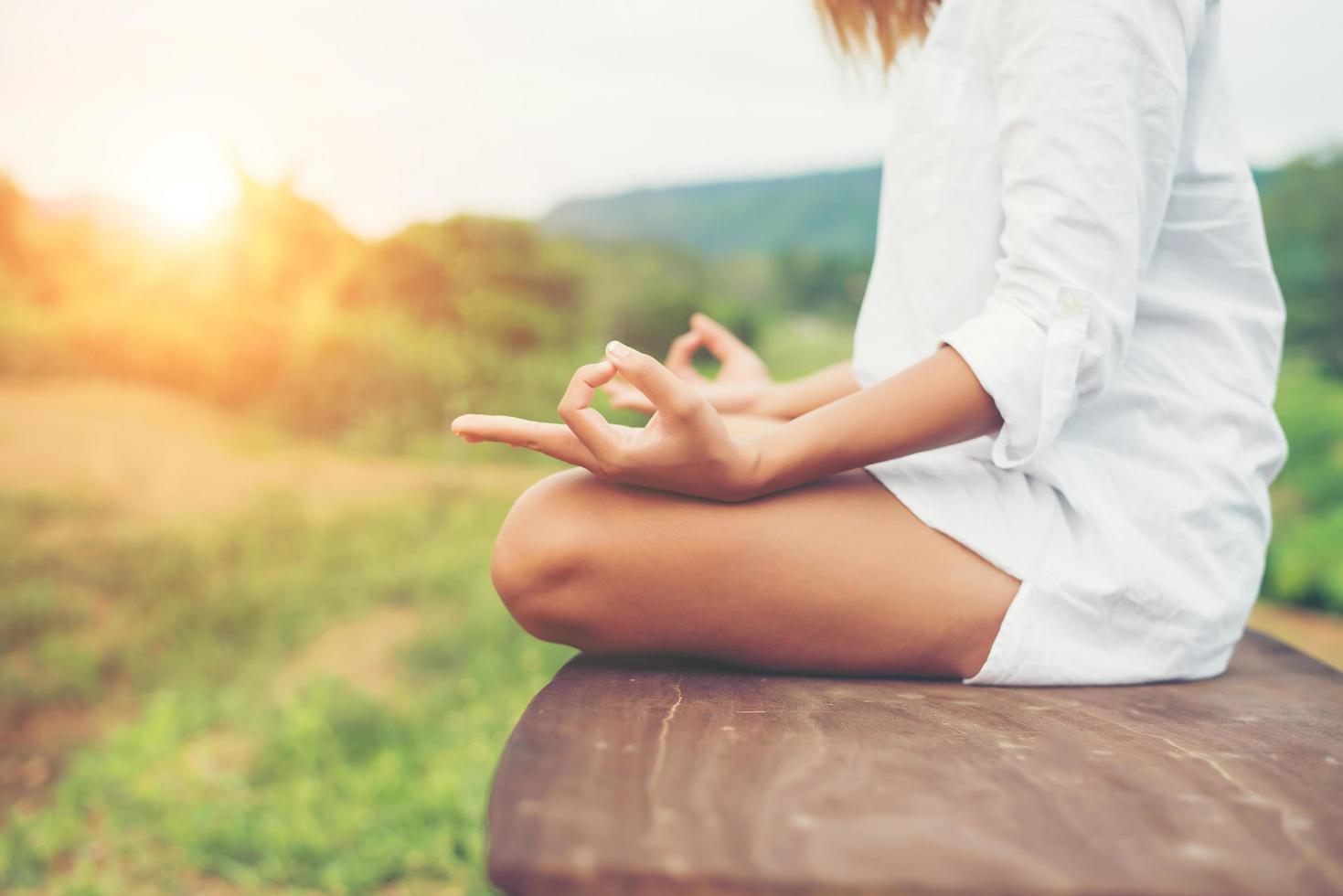 vrouw overhandigt yoga-meditaties en maakt een zen-symbool met haar hand. foto