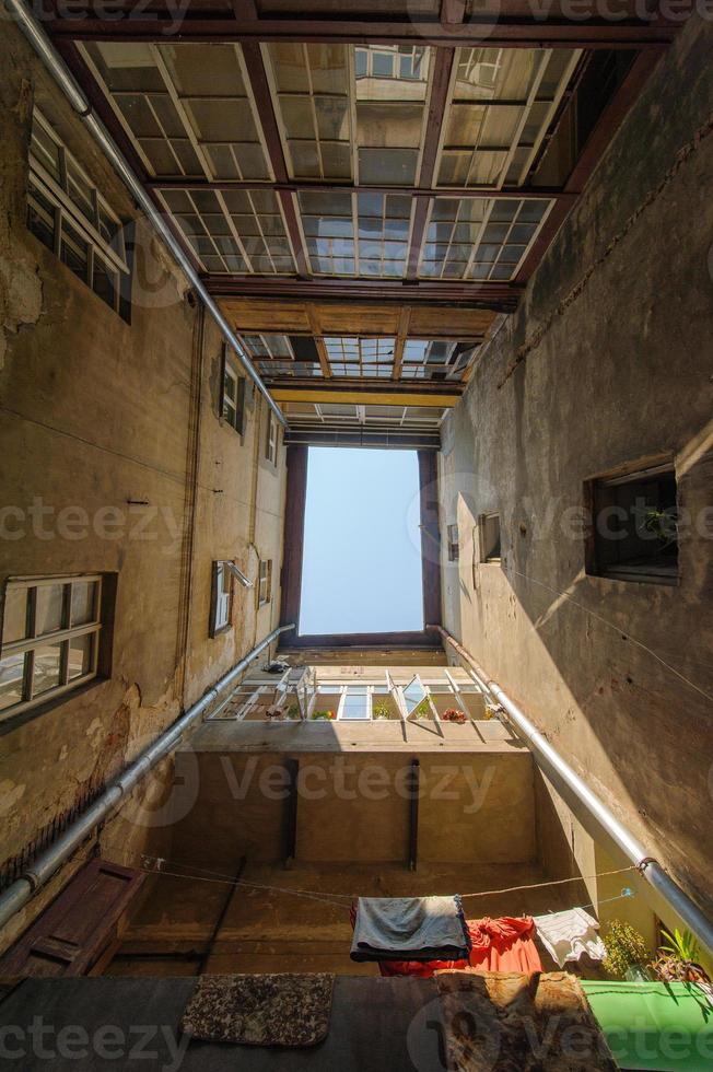 foto van de binnenplaats waar de huizen staan in de vorm van een plein. zicht naar de hemel. de arme oude wijk van de stad.