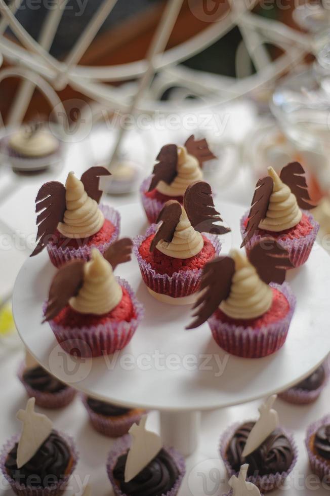 close-up van dienblad met veel heerlijke diversiteit gebak taarten taartjes en bitterkoekjes op een rij. frisse, veelkleurige, kleurrijke, groene, gele, witte en roze zoete bessendesserts, prachtig versierd foto