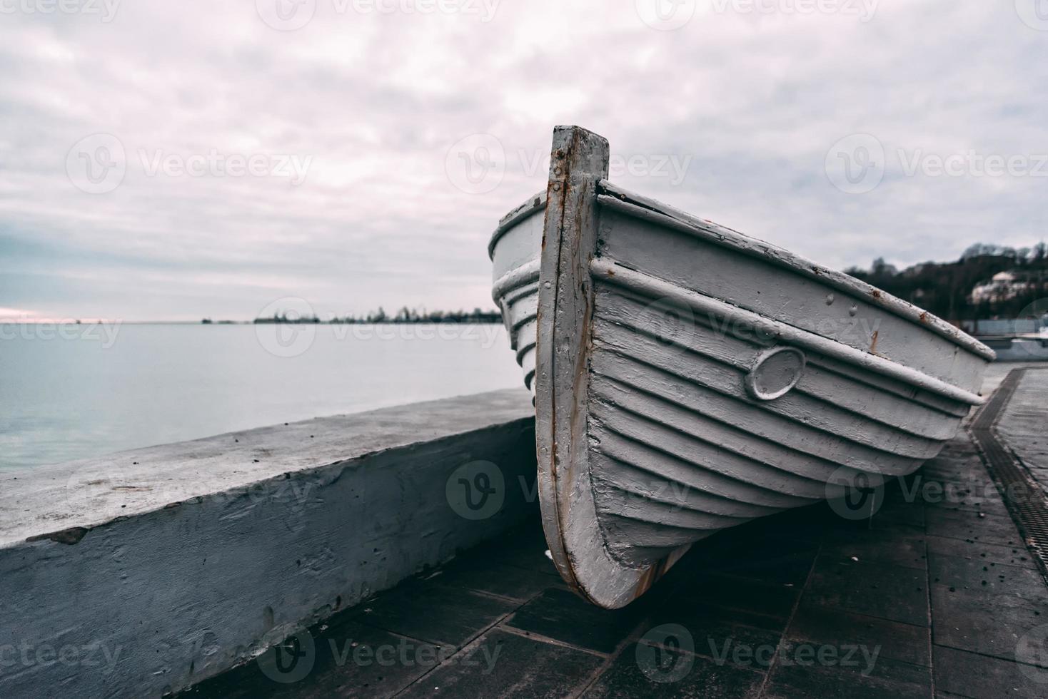 oude houten witte boot op een betonnen pier bij zonsondergang foto