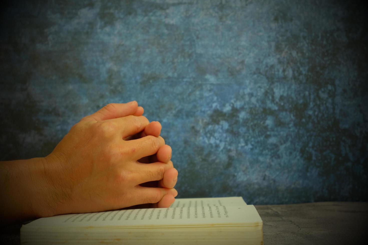 handen gevouwen in gebed op een heilige bijbel in een kerkconcept voor geloof, spiritualiteit en religie, met een vrouw die 's ochtends op de heilige bijbel bidt foto