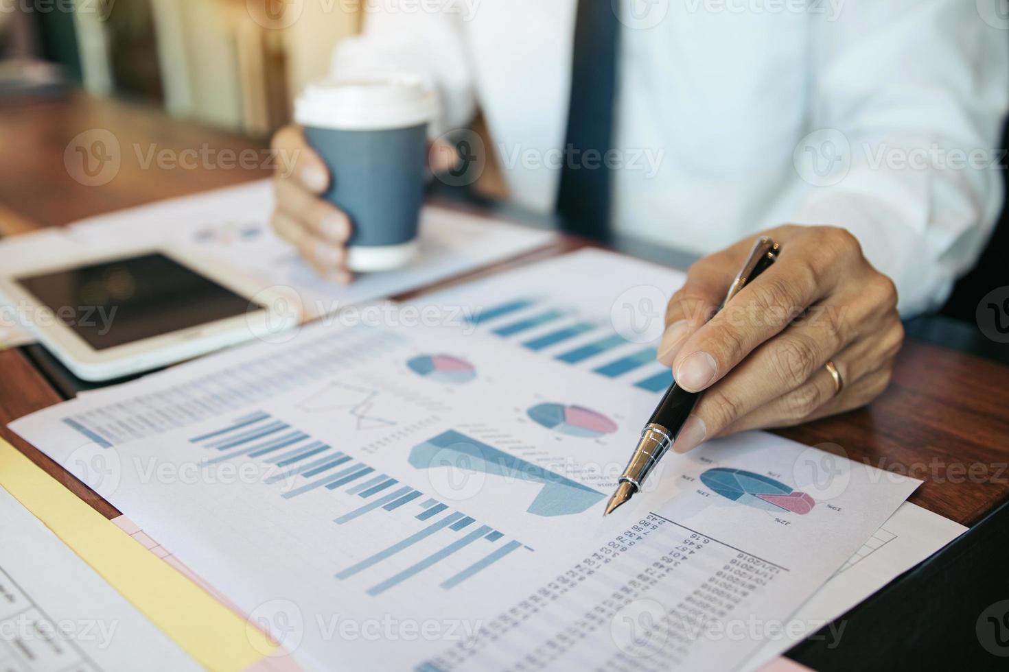 zakenmensen wijzen op het resultaat van het statistieknummer en de financiële kosten van de analyse met het controleren van de samenvattingsrapporten op kantoor. foto