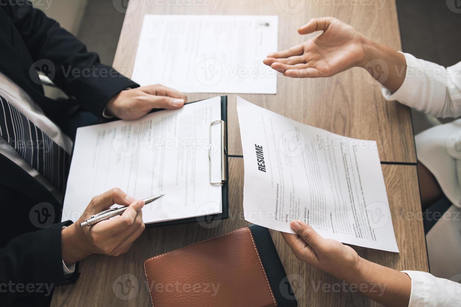 slimme zakenman professionele man in pak uitvoerend gebaren en praten in ontmoeting met interview werknemer vrouwen over werk in moderne kantoren. foto