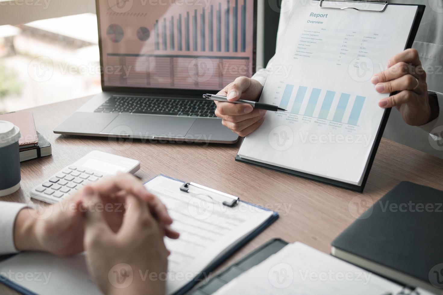 zakelijke werknemer man rapporteert over prestatiegrafieken samenvatting en financiële budgetberekeningen voor managers op kantoor. foto