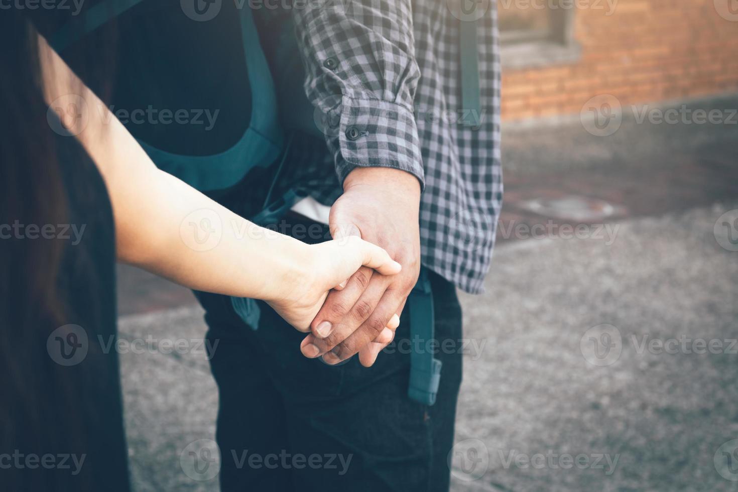 toeristische liefhebbers hand in hand en wandelen in het park. foto