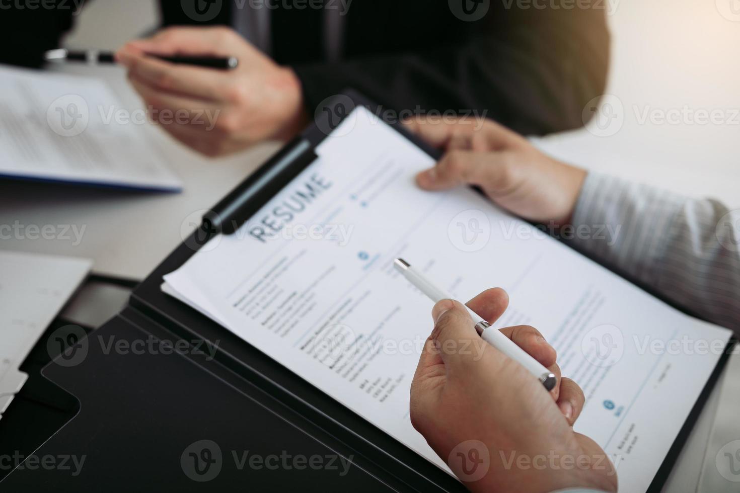 werknemer beschrijft de werkervaring in het cv-papier voor de manager op kantoor. foto