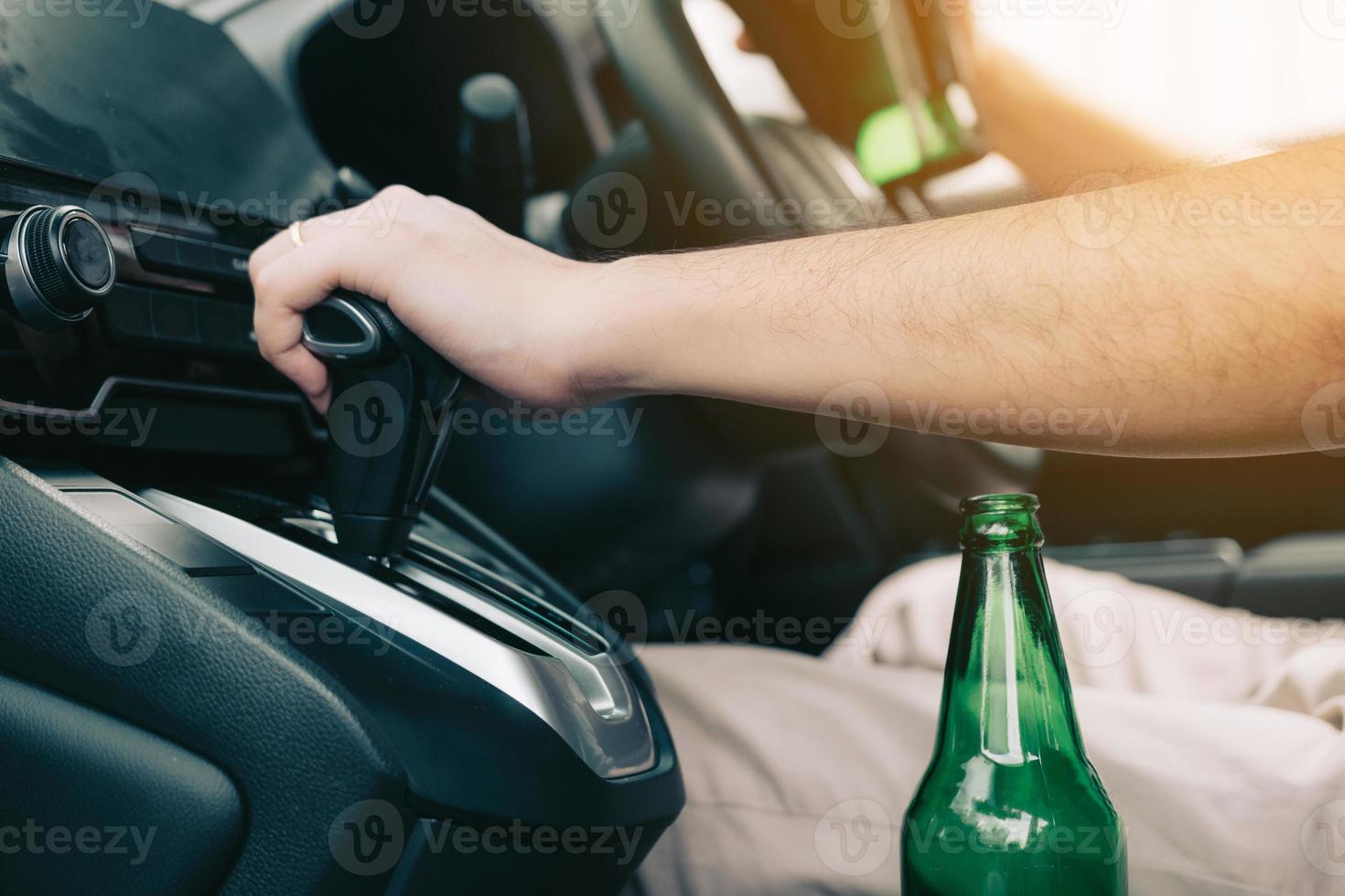 mannen zitten in de uitrusting van de auto en staan klaar om te vertrekken terwijl er een bierflesje in de auto wordt geplaatst. foto