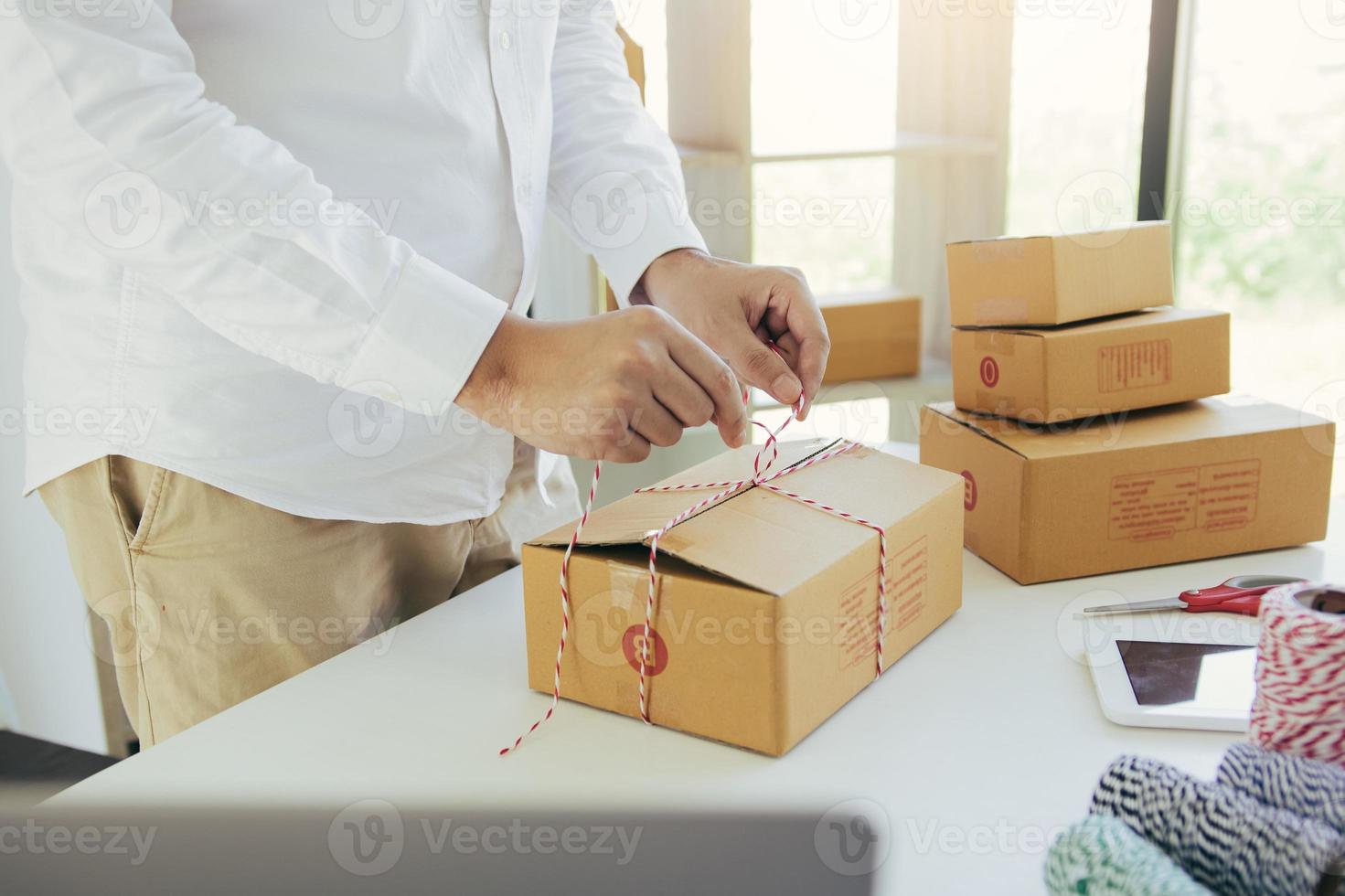 jonge Aziatische tienerproducteigenaren verpakken verpakkingsproducten voor kleine bedrijven in dozen die zijn voorbereid voor verzending. foto