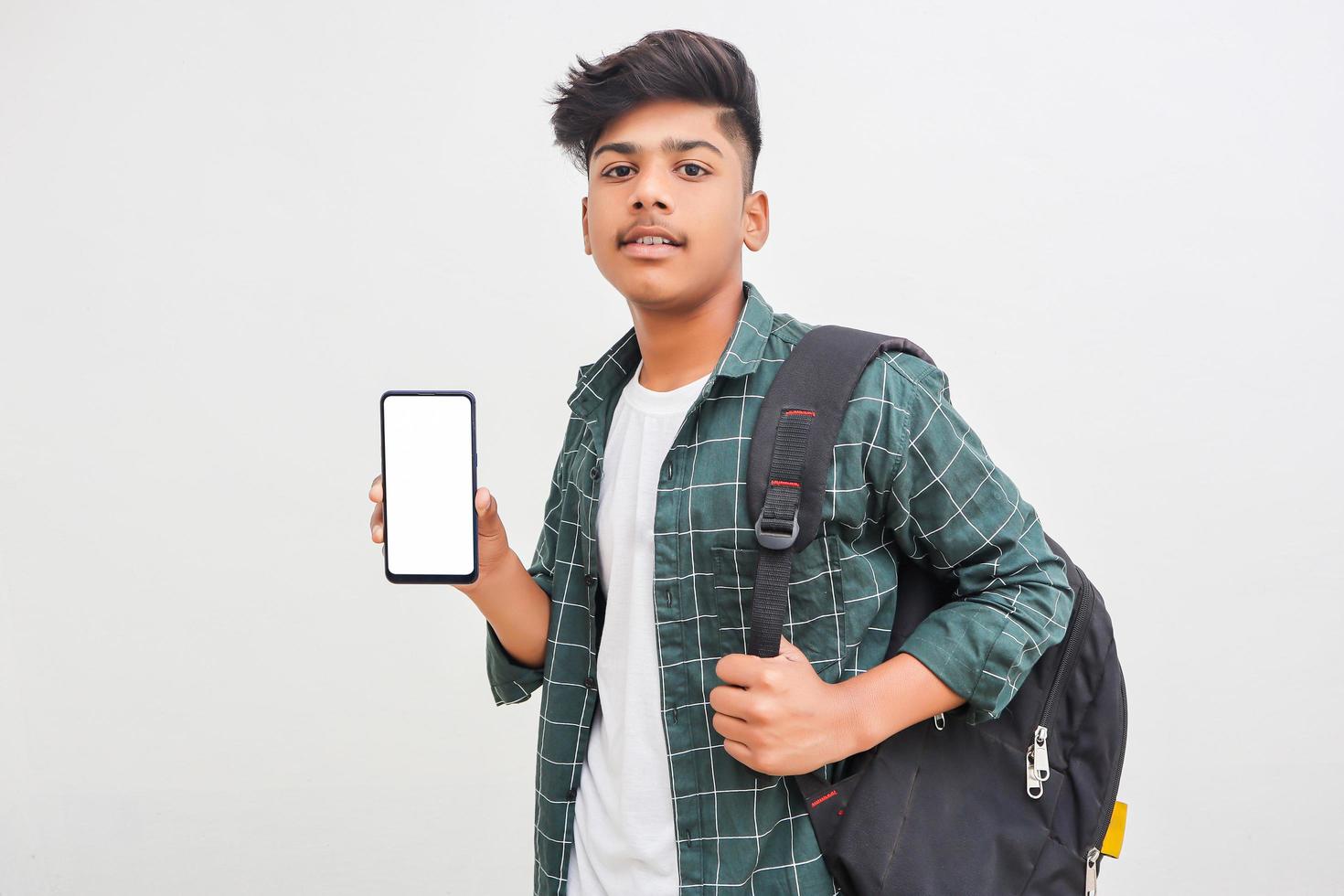 jonge Indiase college student smartphone scherm tonen op witte achtergrond. foto