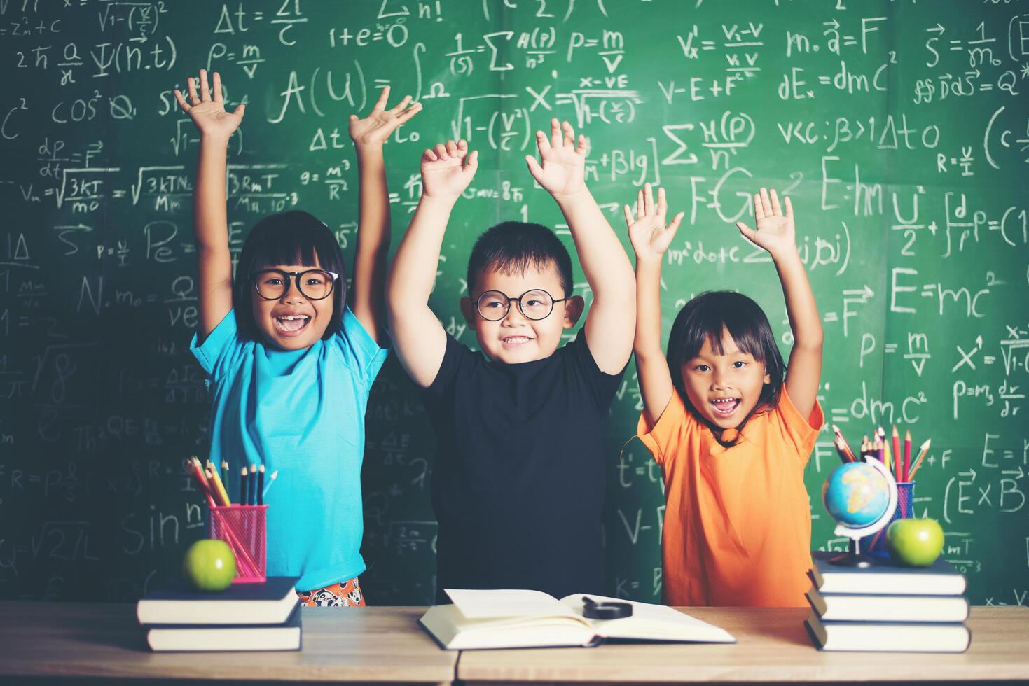 kind steekt zijn hand op in de klas foto