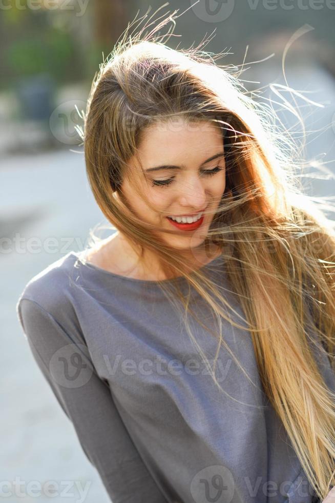 gelukkig blondemeisje in stedelijke achtergrond foto