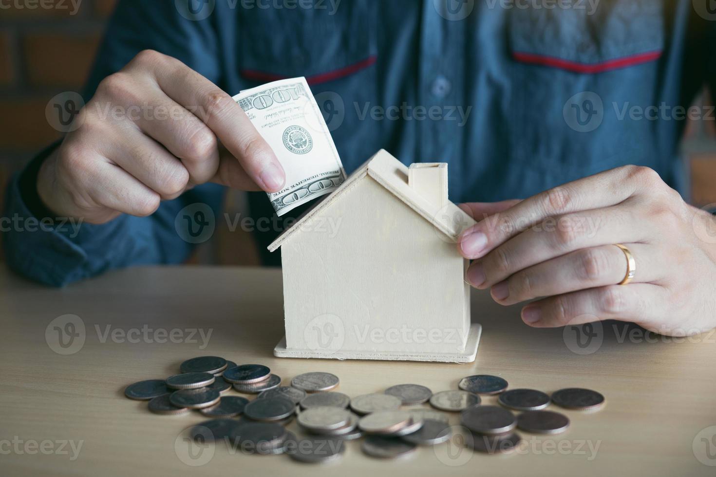 mannen gebruiken bankbiljetten in het spaarvarken thuis met het idee geld in te zamelen om een nieuw huis te kopen. foto