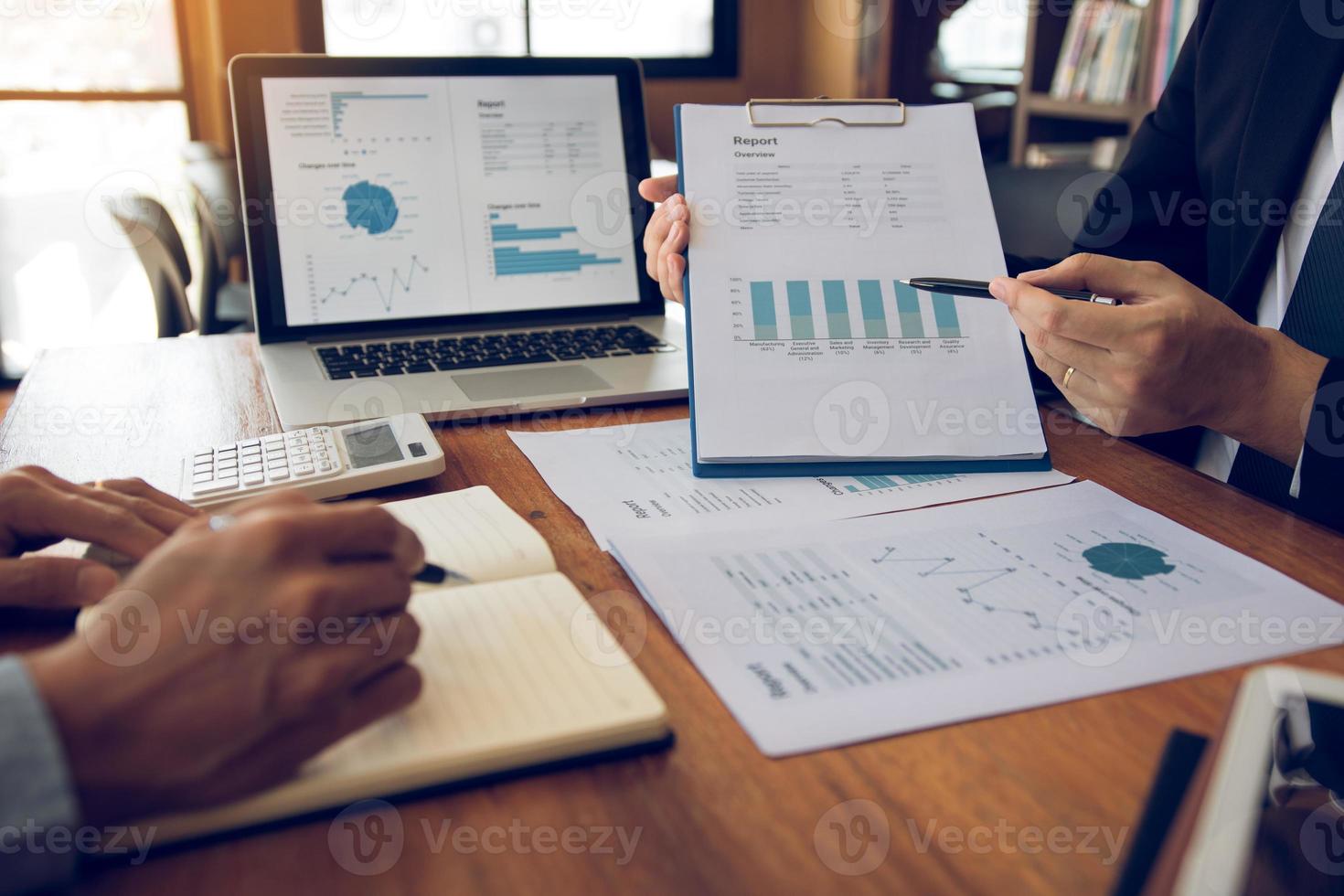 collega's zijn druk aan het praten over het financiële resultatenrapport en vergeleken met de financiële informatie op het papierwerk met analyse over planning in de toekomst. foto