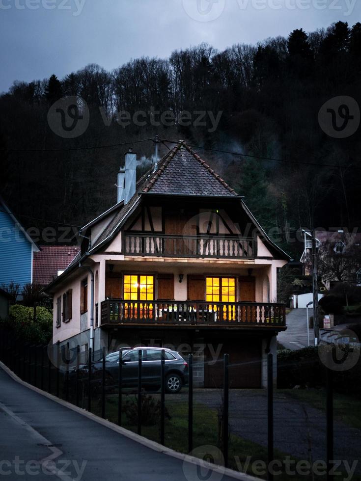 gloeiende warme huiselijke ramen in een klein Elzasser dorp. comfort en warmte in huis op een winteravond. foto