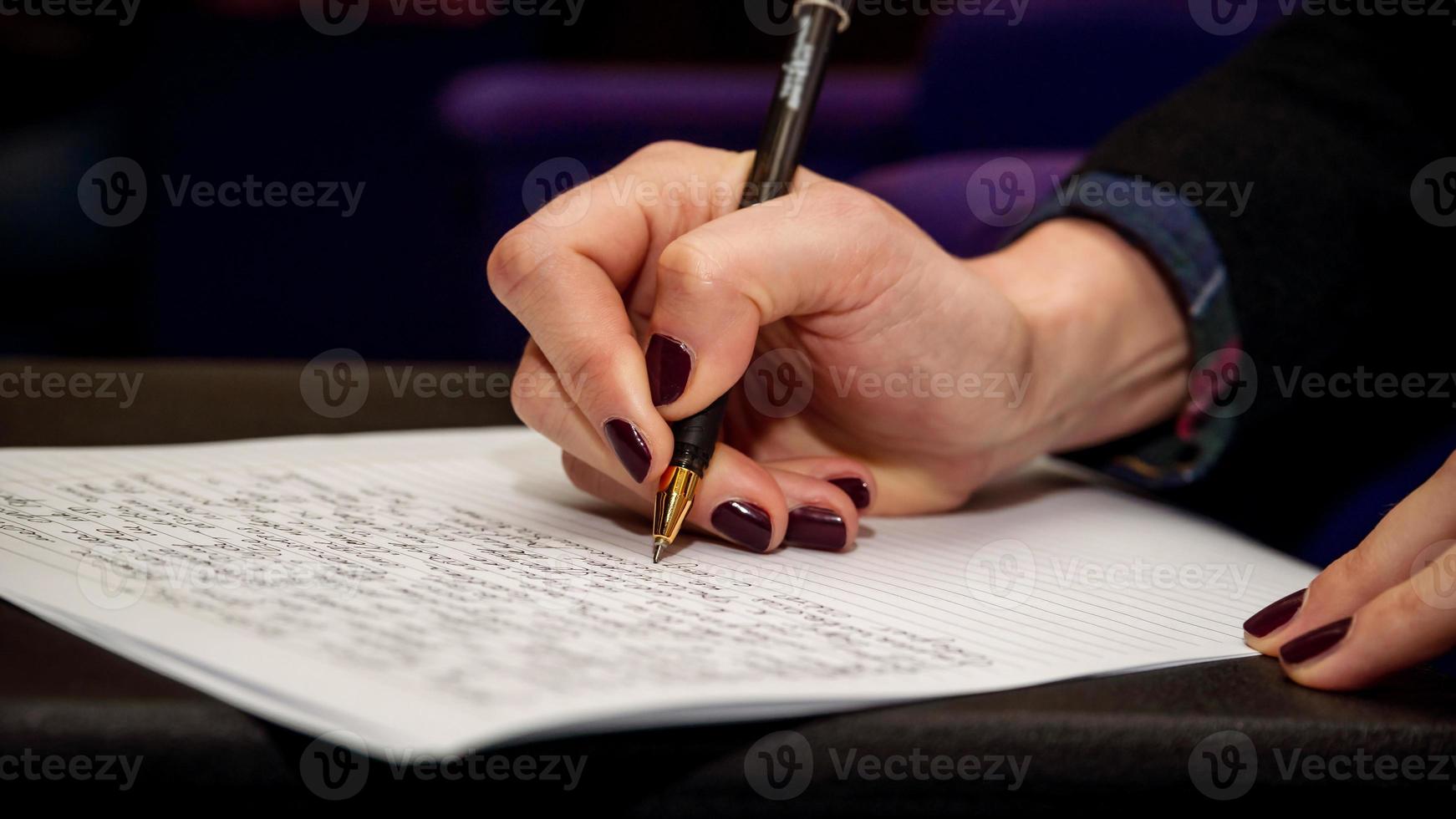 de menselijke hand die tekst schrijft op een vel wit papier foto