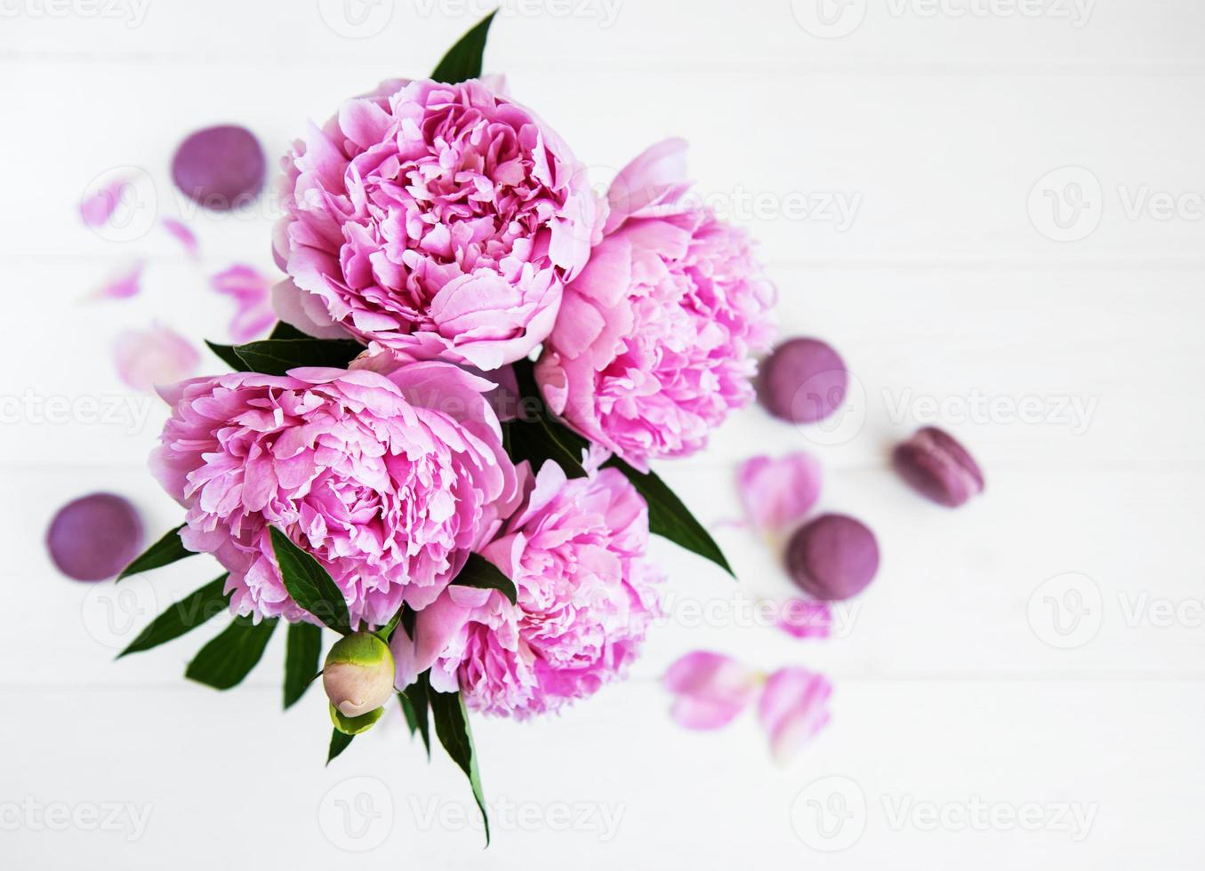 roze pioen met macarons foto