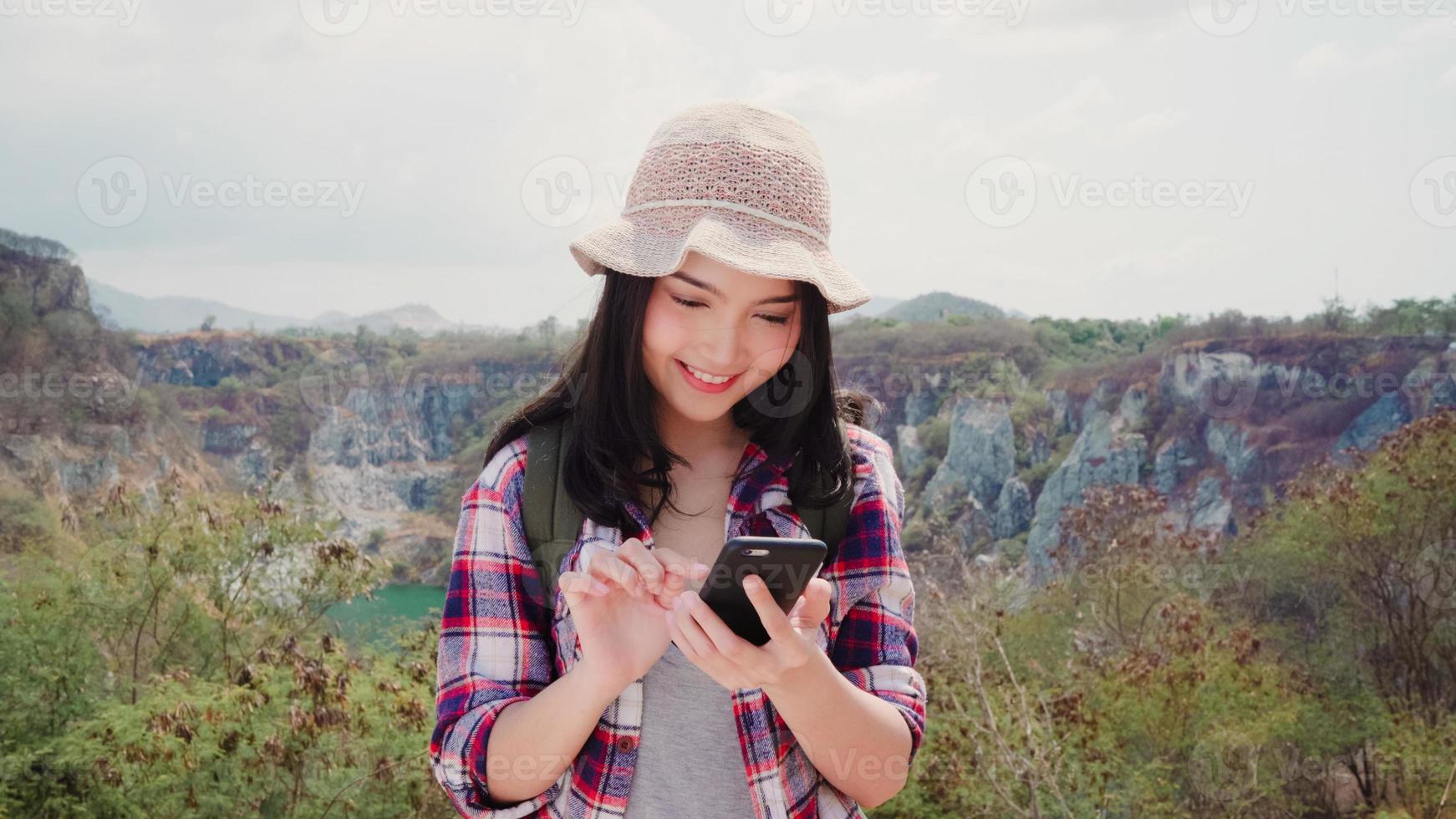 Aziatische backpacker vrouw selfie op de top van de berg, jonge vrouw gelukkig met behulp van mobiele telefoon selfie te nemen geniet van vakantie op wandelavontuur. levensstijl vrouwen reizen en ontspannen concept. foto