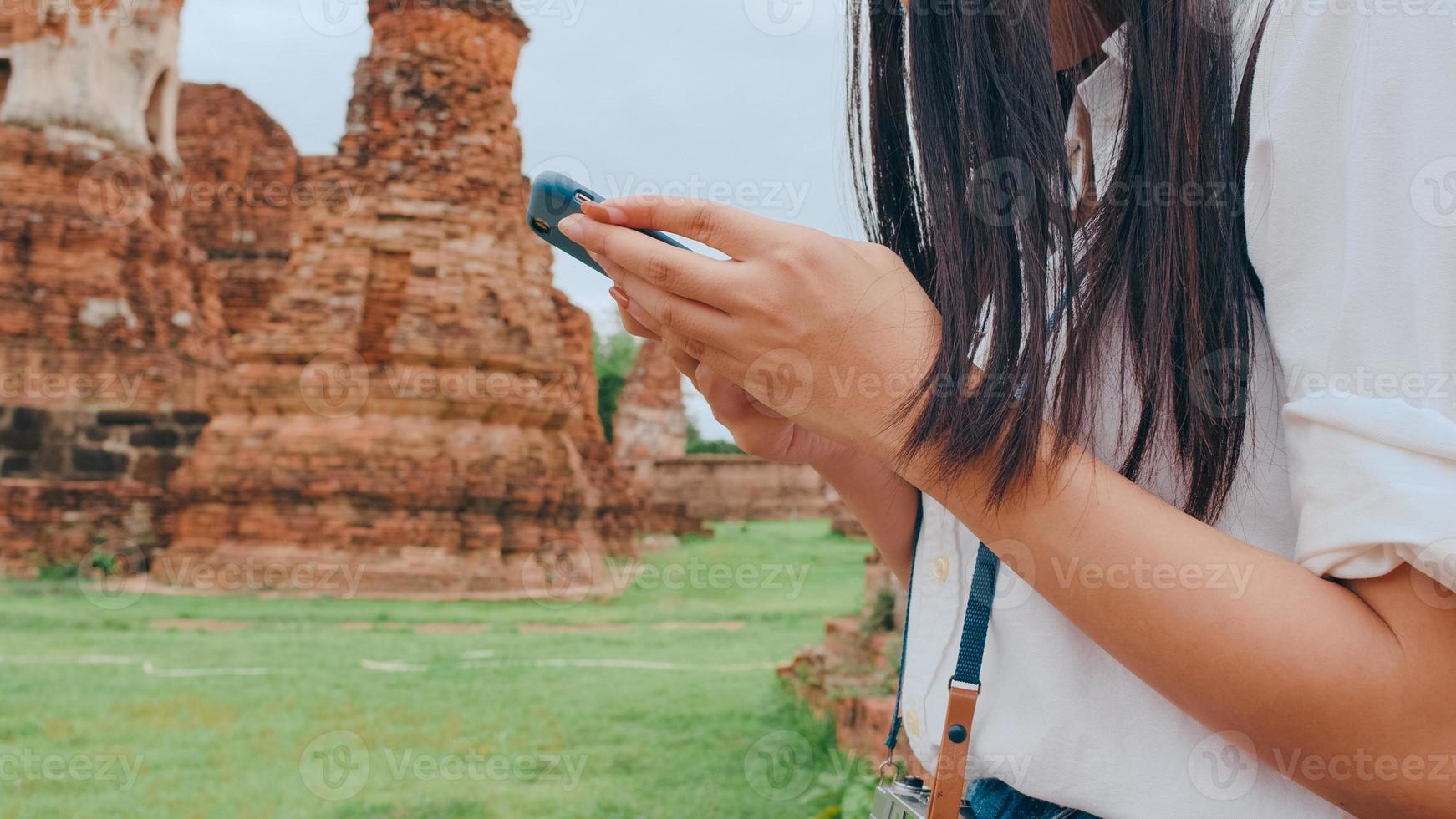 vrolijke mooie jonge Aziatische backpacker blogger vrouw casual met camera kijken naar foto op smartphone glimlach met blij gezicht reizen pagode in de oude stad, lifestyle toeristische reizen vakantie concept.
