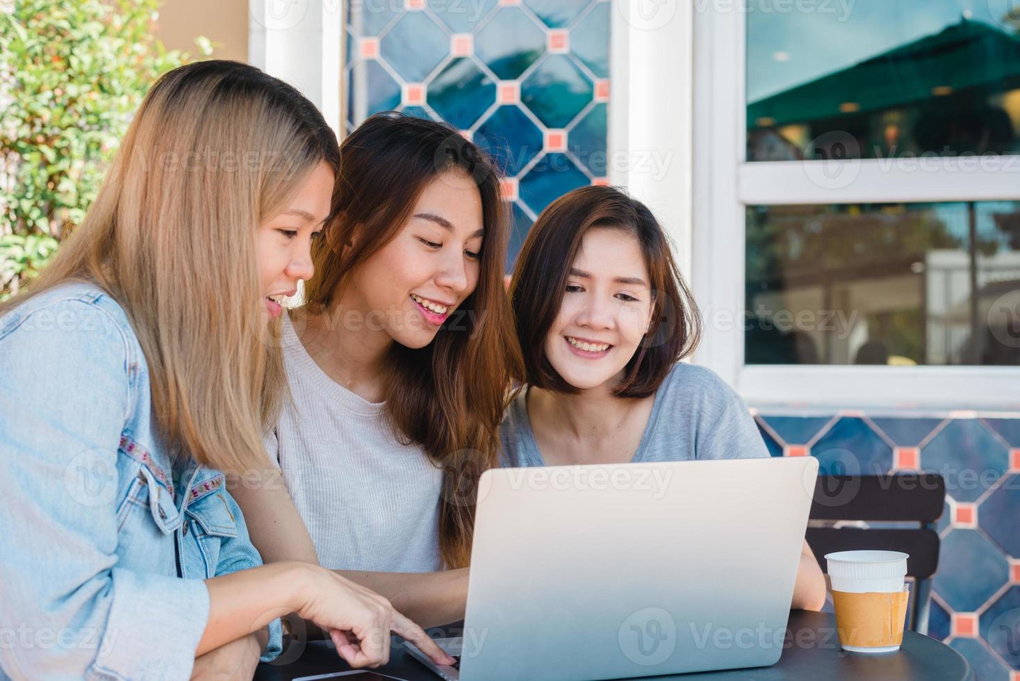 Aziatische jonge vrouwen in slimme vrijetijdskleding die e-mail verzenden op laptop en koffie drinken terwijl ze in een café zitten. lifestyle vrouwen communicatie en werken in coffeeshop concept. foto