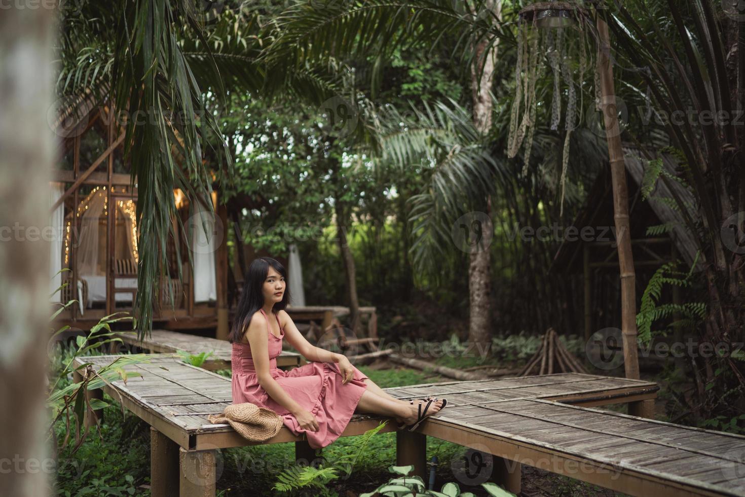 jonge aziatische vrouw ontspannen in het bos, mooie vrouw gelukkig met behulp van ontspannen tijd in de natuur. levensstijl vrouwen reizen in bos concept. foto