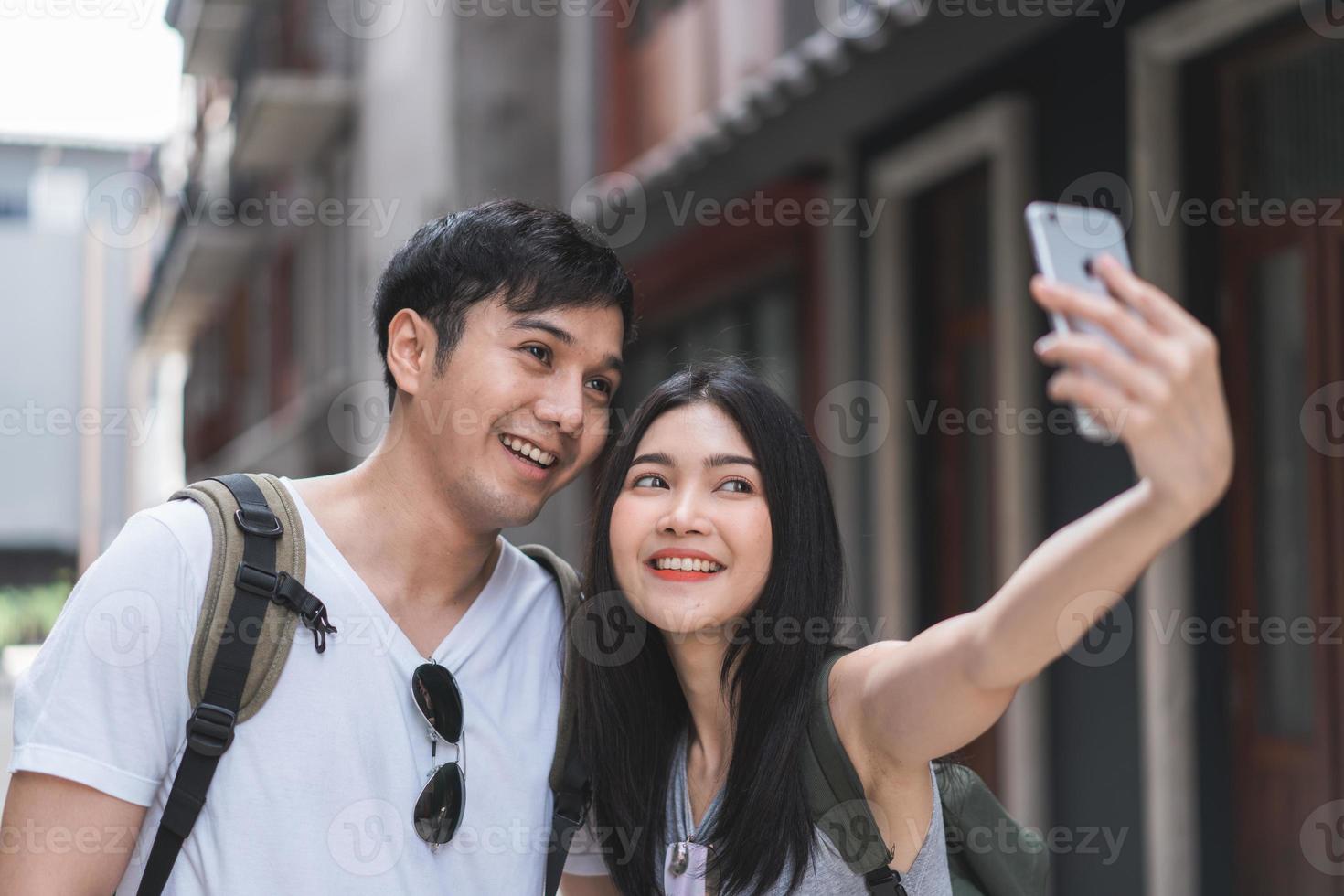 aziatisch blogger-paar reist in beijing, china, lief stel met behulp van mobiele telefoon selfie fotoweergave terwijl ze zoete tijd doorbrengt op vakantiereis. paar reizen in stadsconcept. foto