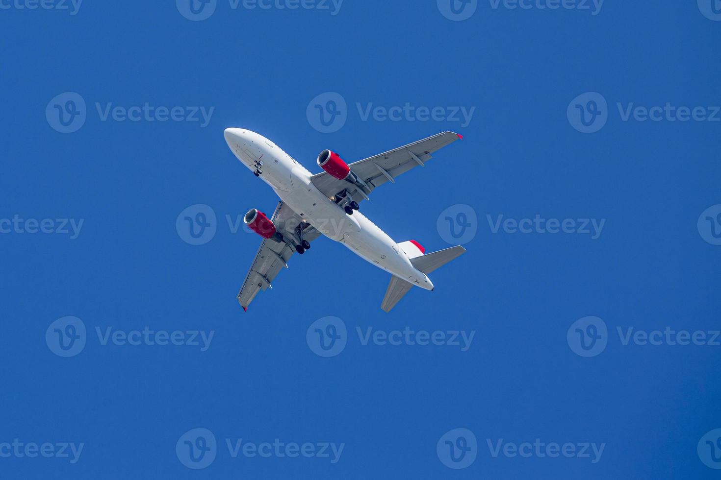 passagiers vliegtuig. bekijk precies van onderen, silhouet tegen de blauwe lucht in oostenrijk. foto