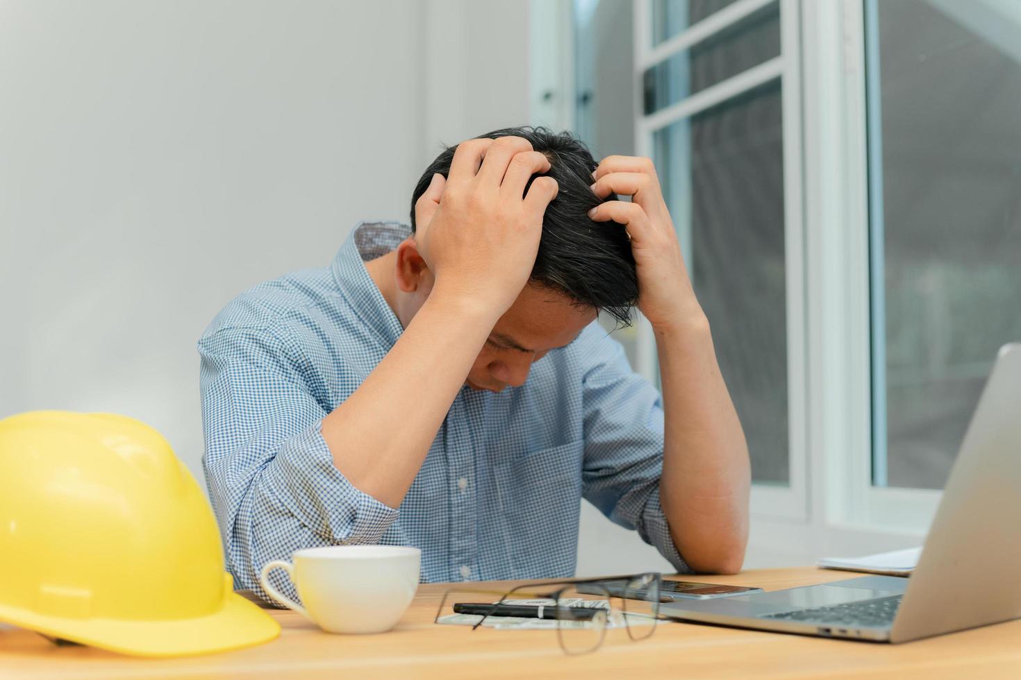 een mannelijke ingenieur die op kantoor zit, is gestrest. foto