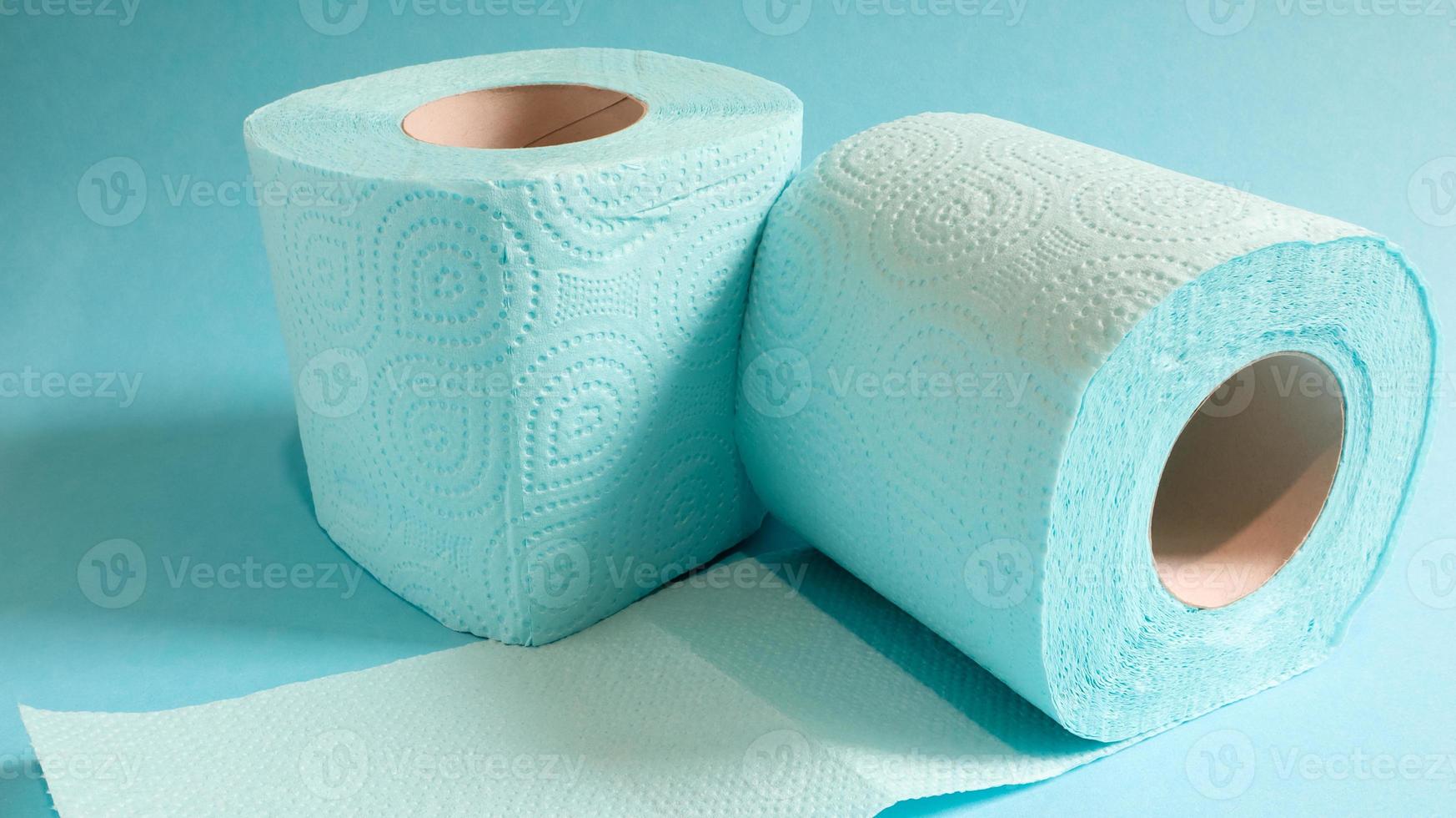 blauwe rol modern toiletpapier op een blauwe achtergrond. een papieren product op een kartonnen hoes, gebruikt voor sanitaire doeleinden van cellulose met uitsparingen om gemakkelijk te scheuren. reliëf tekening foto